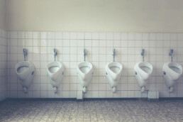 six urinals in titled bathroom