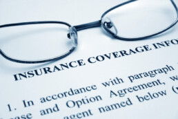 insurance coverage document with glasses on top of it