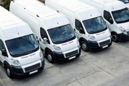 a fleet of white, commercial vans side by side